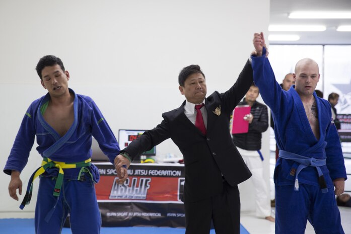 U.S. Marine Corps Lance Cpl. Keegan Cell, an air framer with Marine Aviation Logistics Squadron (MALS) 12, right, gets his hand raised after defeating his opponent during the Duamau Tournament, a jiu jitsu competition at the TK Training Center in Hiroshima, Japan, Feb. 5, 2017. Jiu jitsu is an art of weaponless fighting which employs holds and throws to subdue or disable an opponent. Cell trains among other Marines at the IronWorks North gym on Marine Corps Air Station Iwakuni. (U.S. Marine Corps photo by Lance Cpl. Joseph Abrego)