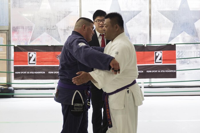 U.S. Marine Corps Master Sgt. Marcos Martinez, expeditionary fire rescue staff noncommissioned officer in charge with Marine Wing Support Squadron (MWSS) 171, left, leans in to hug his opponent after their match during the Duamau Tournament, a jiu jitsu competition at the TK Training Center in Hiroshima, Japan, Feb. 5, 2017. Jiu jitsu is a sport that teaches competitors to respect their opponents and build on the differences. Martinez trains among other Marines at the IronWorks North gym on Marine Corps Air Station Iwakuni. (U.S. Marine Corps photo by Lance Cpl. Joseph Abrego)