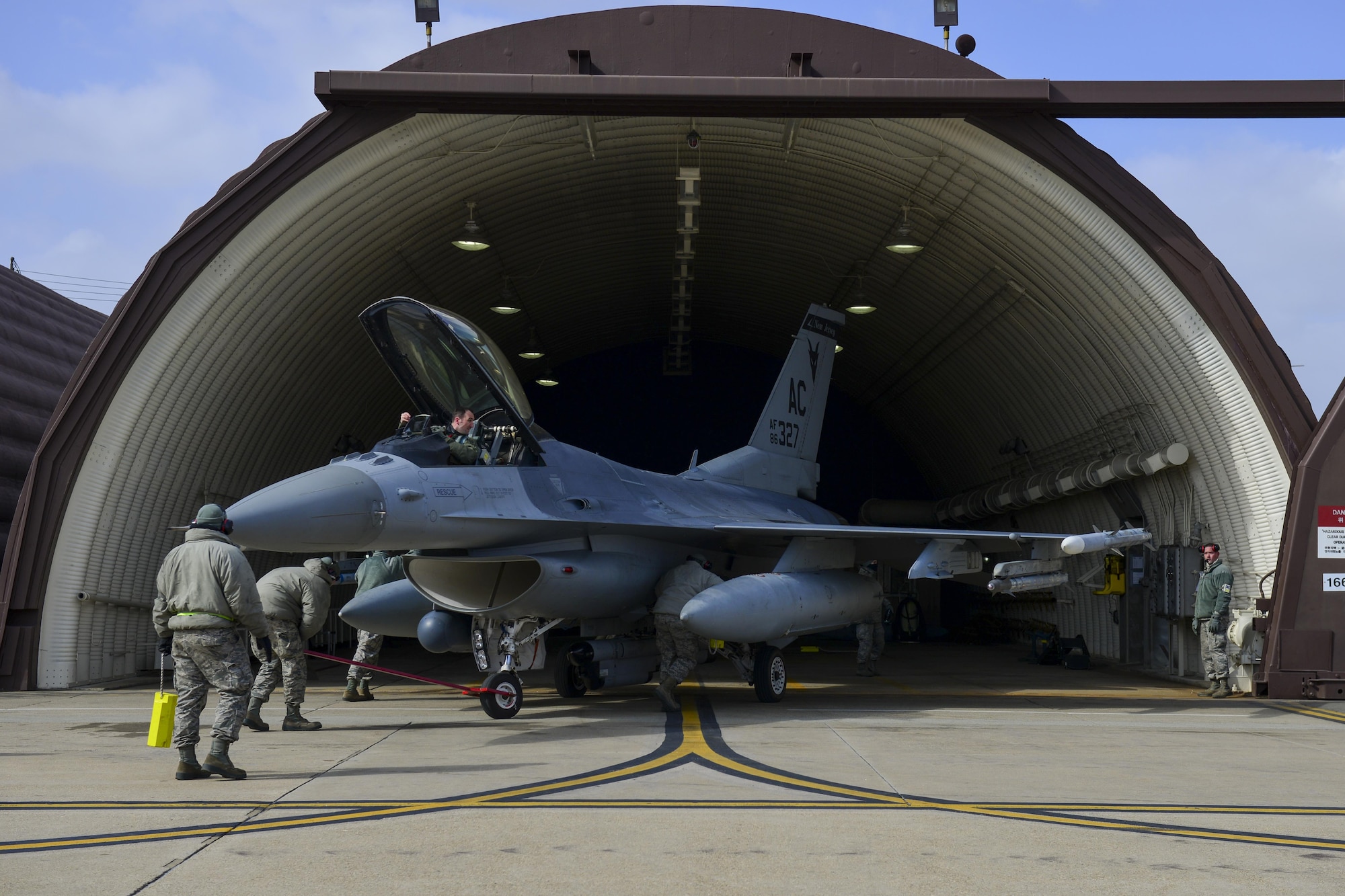 Airmen assigned to the 177th Aircraft Maintenance Squadron from the New Jersey Air National Guard guide an F-16 Fighting Falcon assigned to the 119th Fighter Squadron at Osan Air Base, Republic of Korea, Feb. 9, 2017. The New Jersey Guardsmen are deployed to Osan at the request of Pacific Air Forces, which utilizes Air National Guard units to help bolster the capabilities of allied forces in Korea. (U.S. Air Force photo by Staff Sgt. Victor J. Caputo)