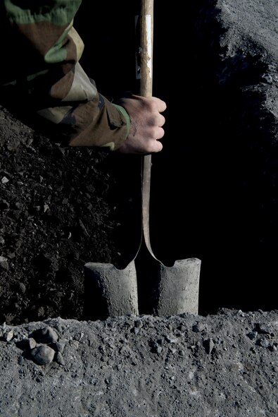 An Airman with the 374th Civil Engineering Squadron cleans out a hole during a Rapid Airfield Damage Repair exercise Feb. 8, 2017, at Yokota Air Base, Japan. The 374 CES can repair about 18 damaged runway areas in approximately six hours using the RADR method. (U.S. Air Force photo by Airman 1st Class Donald Hudson)