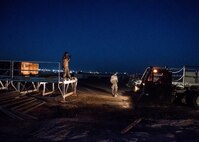 Staff Sgt. Josh Manning, a 386th Expeditionary Logistics Readiness Squadron aerial porter, left, guides a K-loader at an undisclosed location in Southwest Asia, Feb. 2, 2017. Once the K-loader is correctly aligned with the cargo, aerial porters will push the cargo onto the K-loader and transport it to the flightline. (U.S. Air Force photo/Senior Airman Andrew Park)