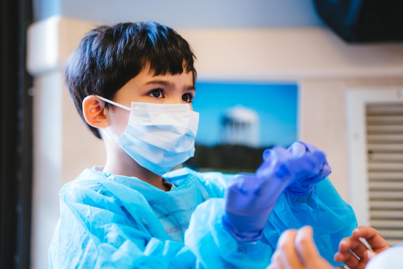 A child tries on a dental gown, mask and gloves at the Child Development Center at Joint Base Andrews, Md., Feb. 3, 2017. Members of the 779th Dental Squadron visited children to share information about the base’s dental clinic as well as techniques to maintain good oral hygiene. (U.S. Air Force photo by Senior Airman Delano Scott) 