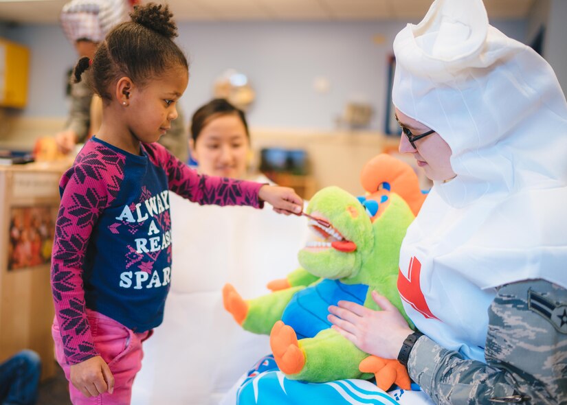 A child brushes a dinosaur puppet’s teeth at the Child Development Center at Joint Base Andrews, Md., Feb. 3, 2017. As part of National Children's Dental Health Month, 779th Dental Squadron Airmen spoke with children about brushing, flossing and eating healthy snacks. (U.S. Air Force photo by Senior Airman Delano Scott)