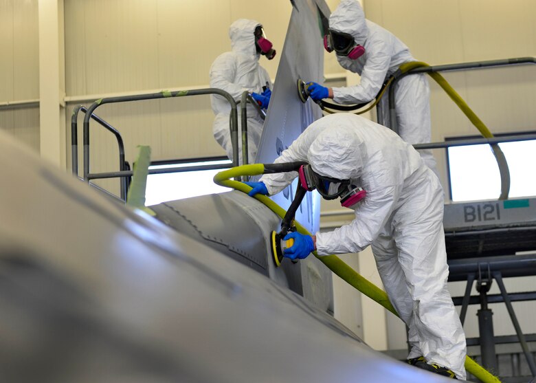 A 31st Maintenance Squadron Corrosions team sands paint off an F-16 Fighting Falcon tail at Aviano Air Base, Italy, Jan. 23, 2017. The team sanded off the paint before painting on a new design. (U.S. Air Force photo by Senior Airman Cary Smith)