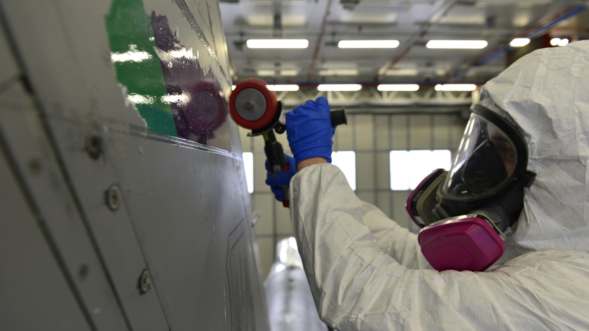 Senior Airman Adam Ciecalone, 31st Maintenance Squadron Aircraft Structural Maintenance journeyman, erases the tail strip from an F-16 Fighting Falcon at Aviano Air Base, Italy, Jan. 23, 2017. Pneumatic erasers are used to remove the tail strip paint. (U.S. Air Force photo by Senior Airman Cary Smith)