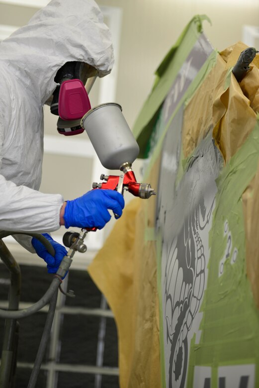 Senior Airman Adam Ciecalone, 31st Maintenance Squadron Aircraft Structural Maintenance journeyman, paints a new design on an F-16 Fighting Falcon tail at Aviano Air Base, Italy, Jan. 27, 2017. Five F-16s received a new tail design. (U.S. Air Force photo by Senior Airman Cary Smith)