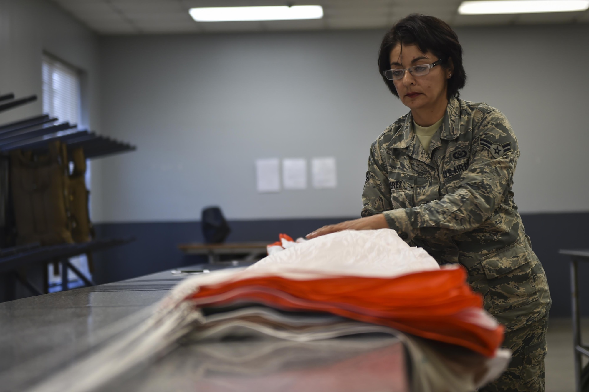 Airman 1st Class Maria Perez, an aircrew flight equipment specialist with the 4th Special Operations Squadron, checks the lines of a low-profile parachute at Hurlburt Field, Fla., Jan. 25, 2017. The equipment specialists are responsible for maintaining flight equipment such as helmets, oxygen masks, harnesses and all life-saving equipment. (U.S. Air Force photo by Airman 1st Class Joseph Pick)