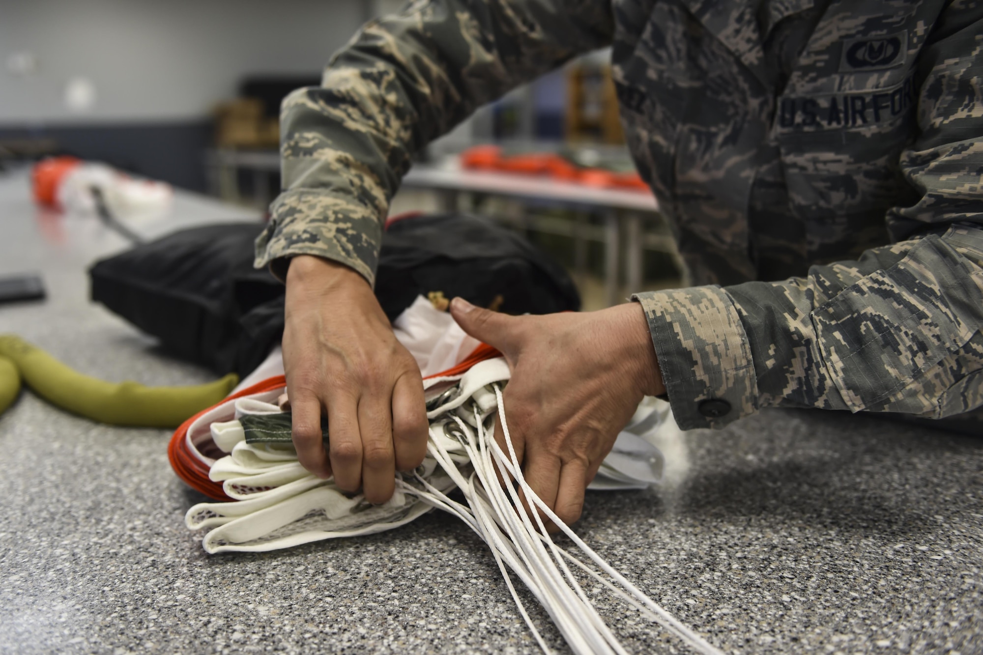 Airman 1st Class Maria Perez, an aircrew flight equipment specialist assigned to the 4th Special Operations Squadron, packs the canopy of a low-profile parachute at Hurlburt Field, Fla., Jan. 25, 2017. Aircrew flight equipment specialists are responsible for maintaining flight equipment such as helmets, oxygen masks, harnesses and all life-saving equipment. (U.S. Air Force photo by Airman 1st Class Joseph Pick)