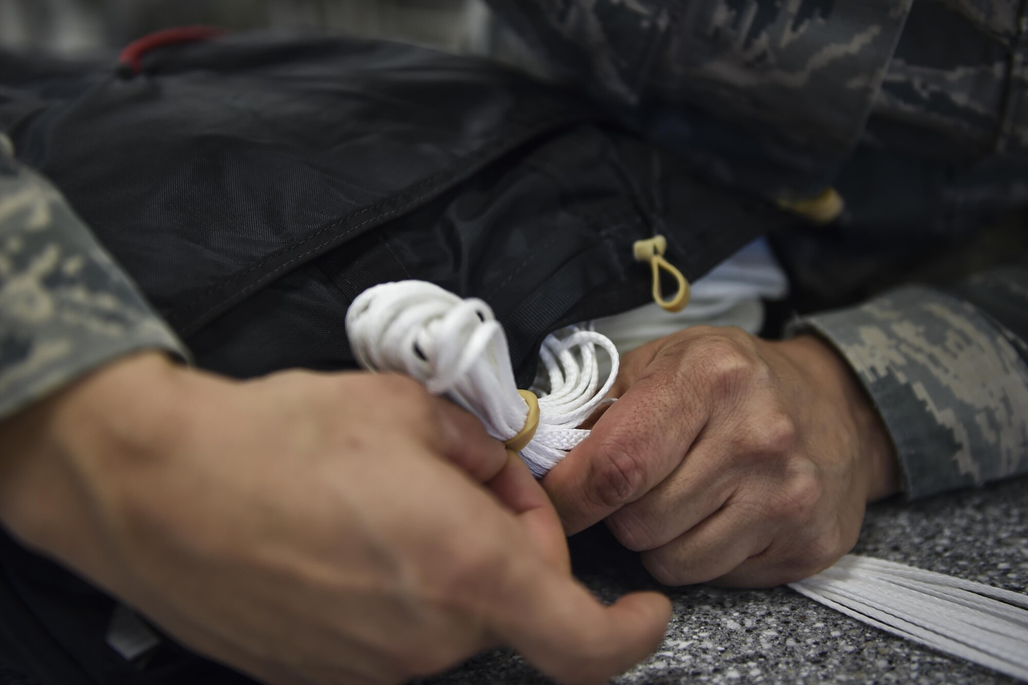 Airman 1st Class Maria Perez, an aircrew flight equipment specialist with the 4th Special Operations Squadron, secures the suspension lines of a low-profile parachute at Hurlburt Field, Fla., Jan. 25, 2017. The LPP is configured for use in the AC-130 gunships and replaced the BA-22 parachute. The LPP weighs approximately 20 pounds, roughly half of the BA-22. (U.S. Air Force photo by Airman 1st Class Joseph Pick)