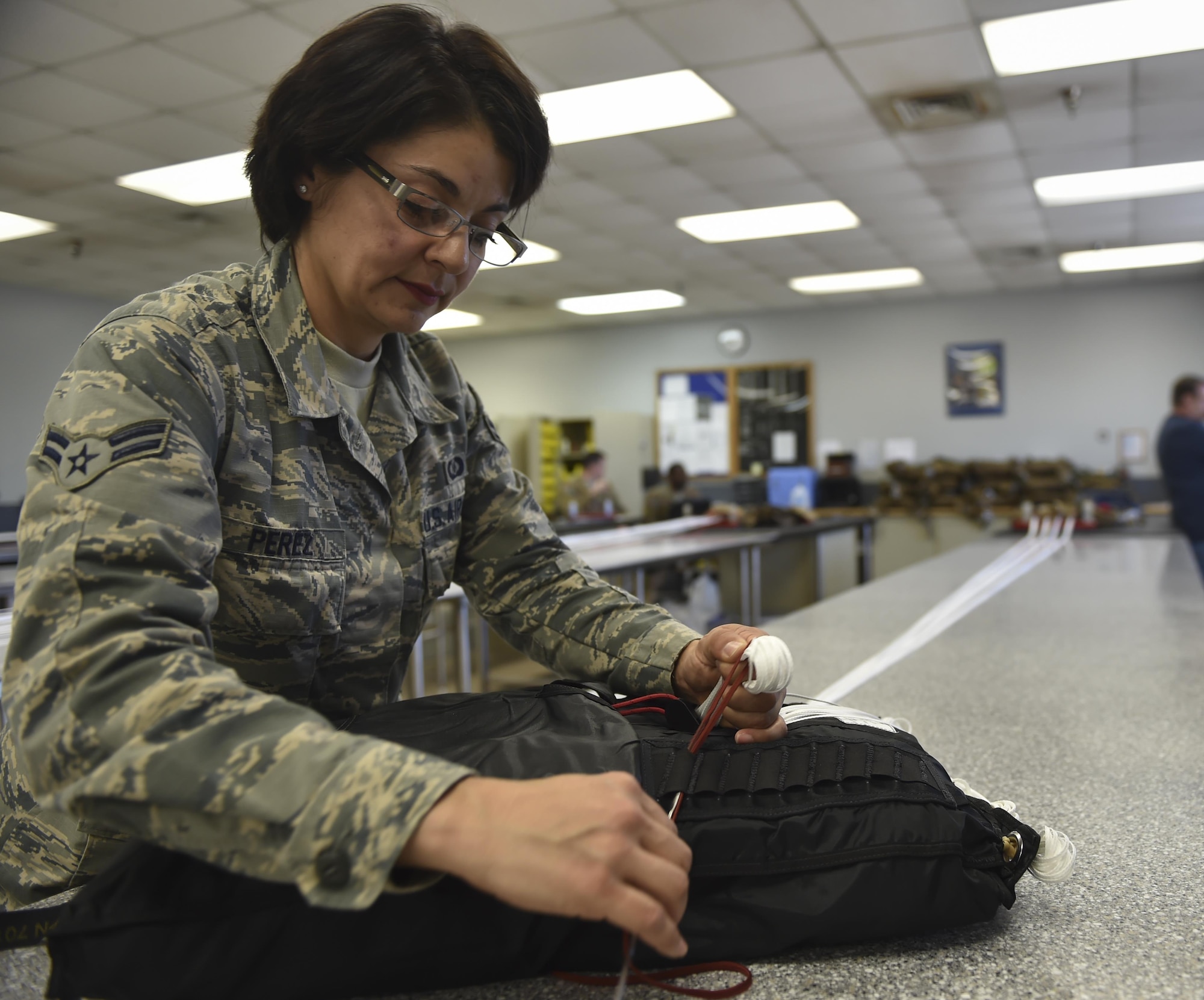 Airman 1st Class Maria Perez, an aircrew flight equipment specialist with the 4th Special Operations Squadron, secures suspension lines for a low-profile parachute to a deployment bag at Hurlburt Field, Fla., Jan. 25, 2017. The LPP is configured for use in the AC-130 gunships and replaced the BA-22 parachute. The LPP weighs approximately 20 pounds, roughly half of the BA-22. (U.S. Air Force photo by Airman 1st Class Joseph Pick)