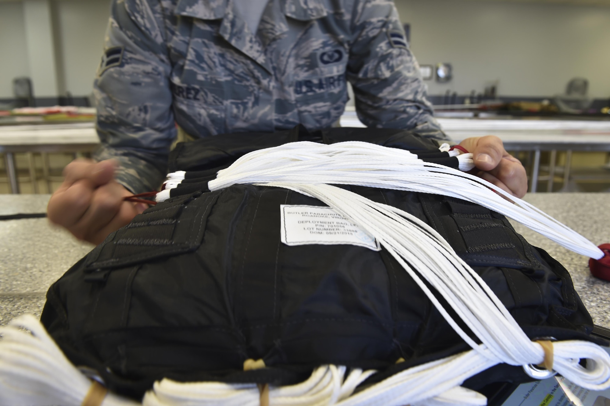 Airman 1st Class Maria Perez, an aircrew flight equipment specialist with the 4th Special Operations Squadron, secures suspension lines for a low-profile parachute to a deployment bag at Hurlburt Field, Fla., Jan. 25, 2017. The LPP is configured for use in the AC-130 gunships and replaced the BA-22 parachute. The LPP weighs approximately 20 pounds, roughly half of the BA-22. (U.S. Air Force photo by Airman 1st Class Joseph Pick)