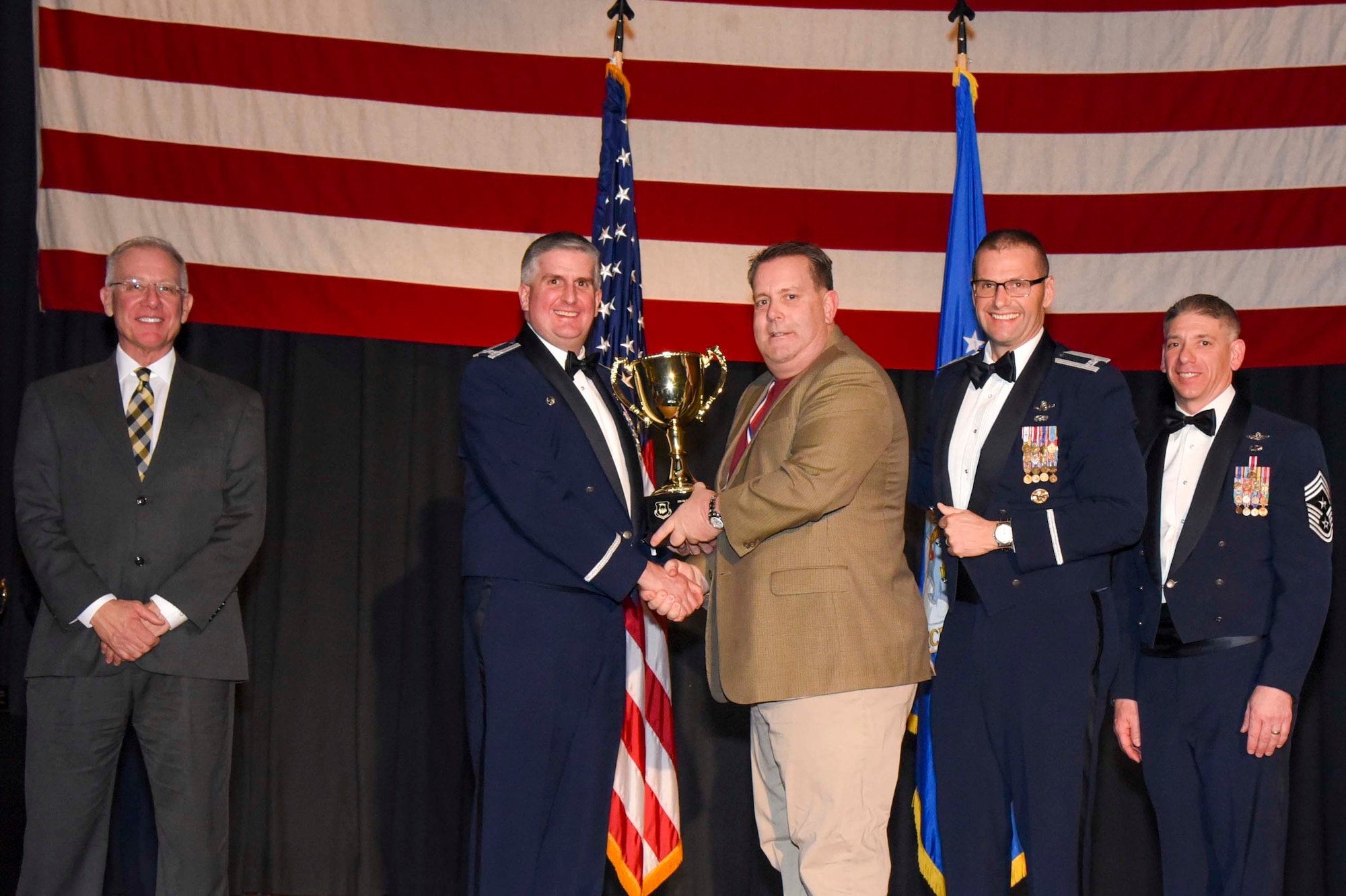 Stephen J. Yavornitzki, 22nd Wing Staff Agencies, center, accepts the 2016 Civilian Category II of the Year award, Feb. 3, 2017, at McConnell Air Force Base, Kan. The annual awards ceremony recognized military and civilian members who excel in their areas of responsibilities, leadership qualities, community involvement, self-improvement and innovation from January to December 2016. (U.S. Air Force photo/Senior Airman Christopher Thornbury)