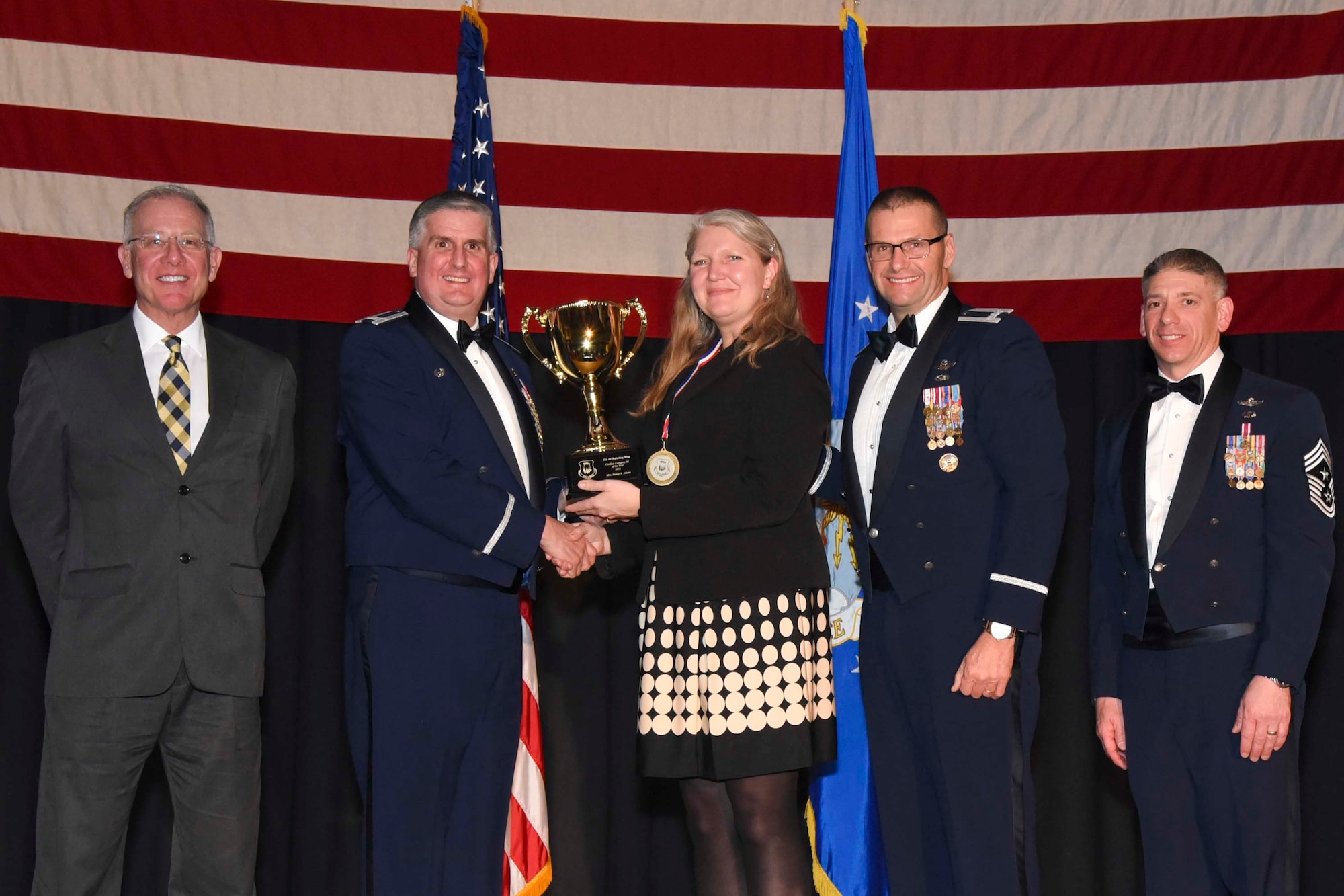Nancy A. Adams, 22nd Force Support Squadron, center, accepts the 2016 Civilian Category III of the Year award, Feb. 3, 2017, at McConnell Air Force Base, Kan. The annual awards ceremony recognized military and civilian members who excel in their areas of responsibilities, leadership qualities, community involvement, self-improvement and innovation from January to December 2016. (U.S. Air Force photo/Senior Airman Christopher Thornbury)
