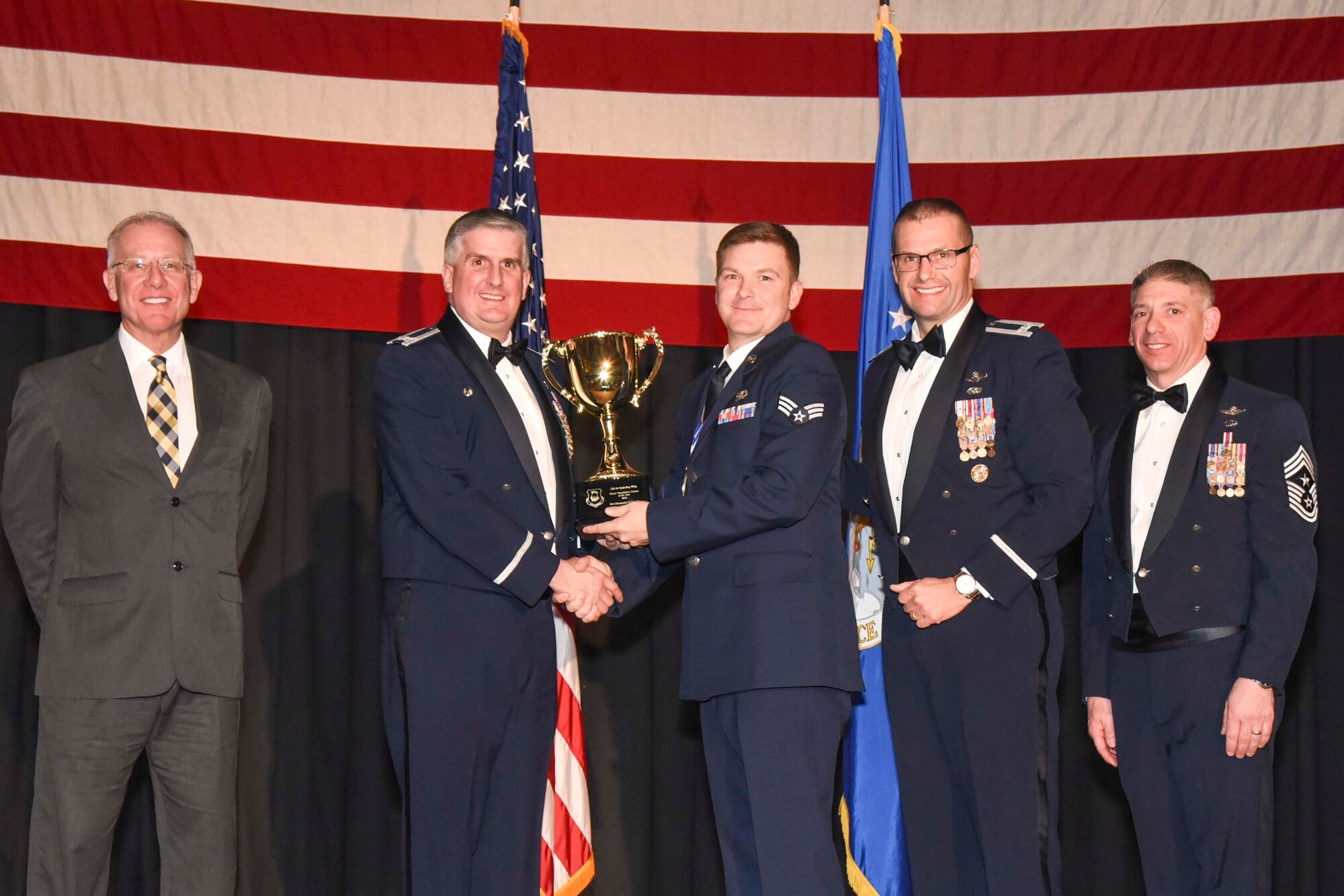 Senior Airman Christopher P. Lippolis, 22nd Operations Support Squadron, center, accepts the 2016 Honor Guardsman of the Year, Airman award, Feb. 3, 2017, at McConnell Air Force Base, Kan. The annual awards ceremony recognized military and civilian members who excel in their areas of responsibilities, leadership qualities, community involvement, self-improvement and innovation during the period of January to December 2016. (U.S. Air Force photo/Senior Airman Christopher Thornbury)