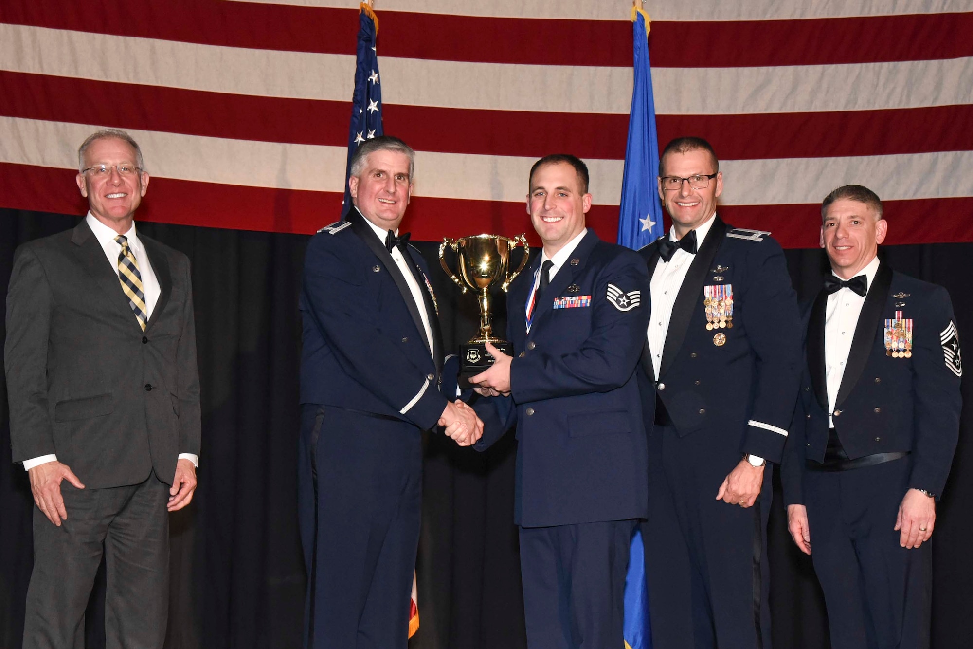 Staff Sgt. Eric Keen, 22nd Aircraft Maintenance Squadron, center, accepts the 2016 Honor Guardsman of the Year, NCO award, Feb. 3, 2017, at McConnell Air Force Base, Kan. The annual awards ceremony recognized military and civilian members who excel in their areas of responsibilities, leadership qualities, community involvement, self-improvement and innovation during the period of January to December 2016. (U.S. Air Force photo/Senior Airman Christopher Thornbury)