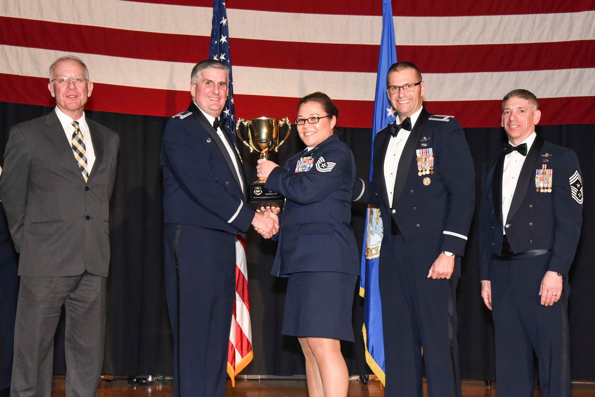 Tech. Sgt. Kathrine M. Johns, 22nd Security Forces Squadron, center, accepts the 2016 Volunteer of the Year, Feb. 3, 2017, at McConnell Air Force Base, Kan. The annual awards ceremony recognized military and civilian members who excel in their areas of responsibilities, leadership qualities, community involvement, self-improvement and innovation from January to December 2016. (U.S. Air Force photo/Senior Airman Christopher Thornbury)