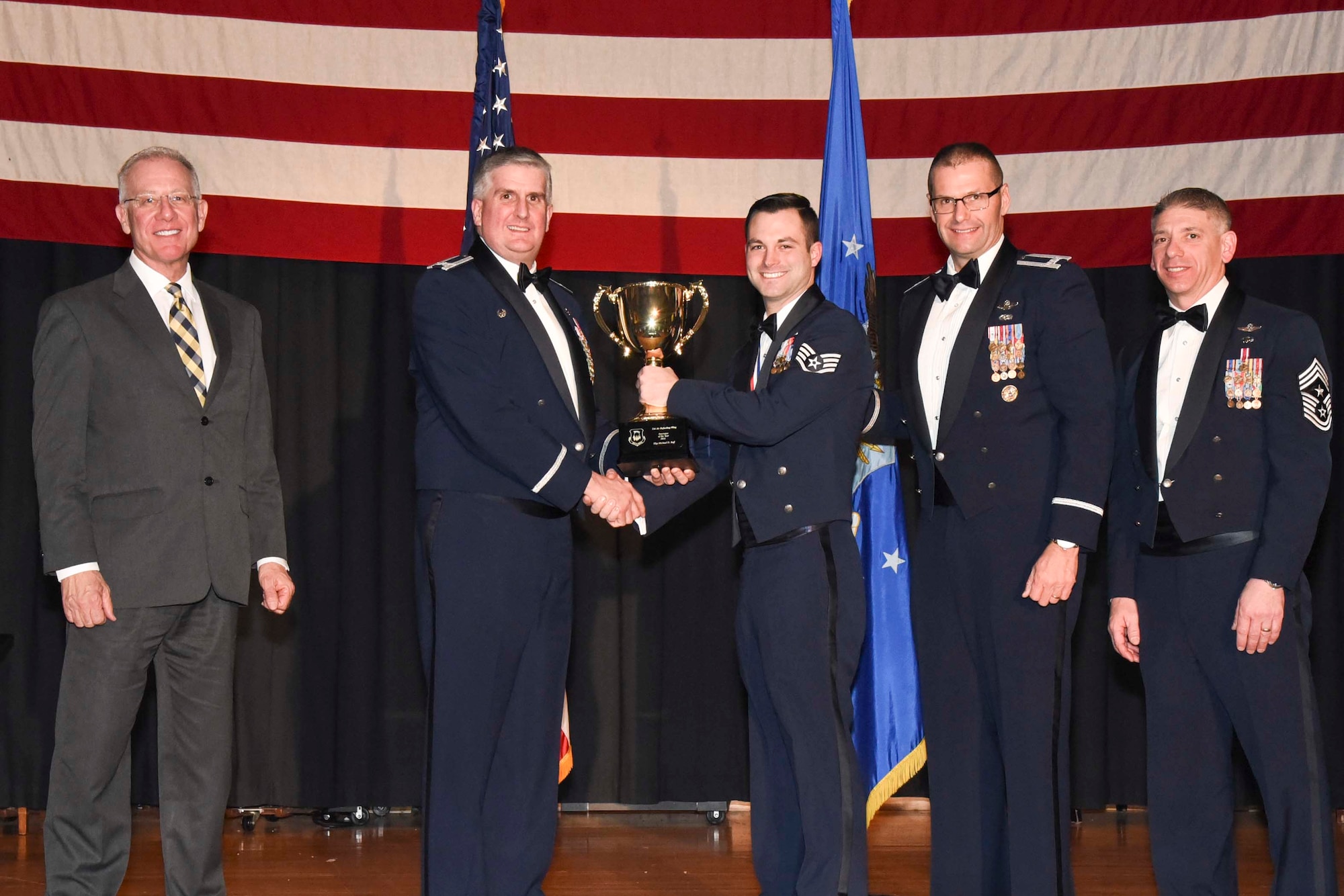 Staff Sgt. Michael D. Ruff, 22nd Security Forces Squadron, center, accepts the 2016 Innovator of the Year award, Feb. 3, 2017, at McConnell Air Force Base, Kan. The annual awards ceremony recognized military and civilian members who excel in their areas of responsibilities, leadership qualities, community involvement, self-improvement and innovation during the period of January to December 2016. (U.S. Air Force photo/Senior Airman Christopher Thornbury)