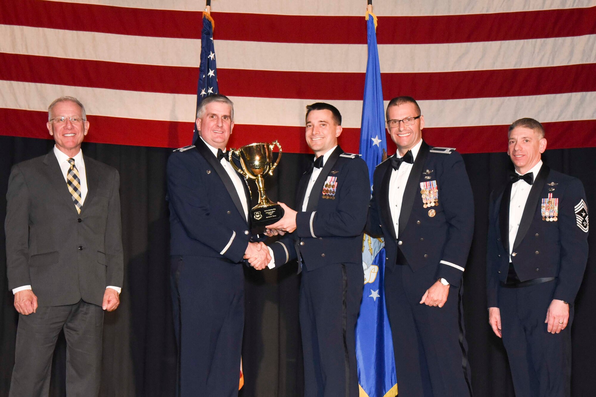 Lt. Col. Aaron Walenga, 22nd Operations Squadron commander, center, accepts the 2016 Field Grade Officer of the Year award on behalf of Maj. Jared R. Thomas, Feb. 3, 2017, at McConnell Air Force Base, Kan. The annual awards ceremony recognized military and civilian members who excel in their areas of responsibilities, leadership qualities, community involvement, self-improvement and innovation from January to December 2016. (U.S. Air Force photo/Senior Airman Christopher Thornbury)