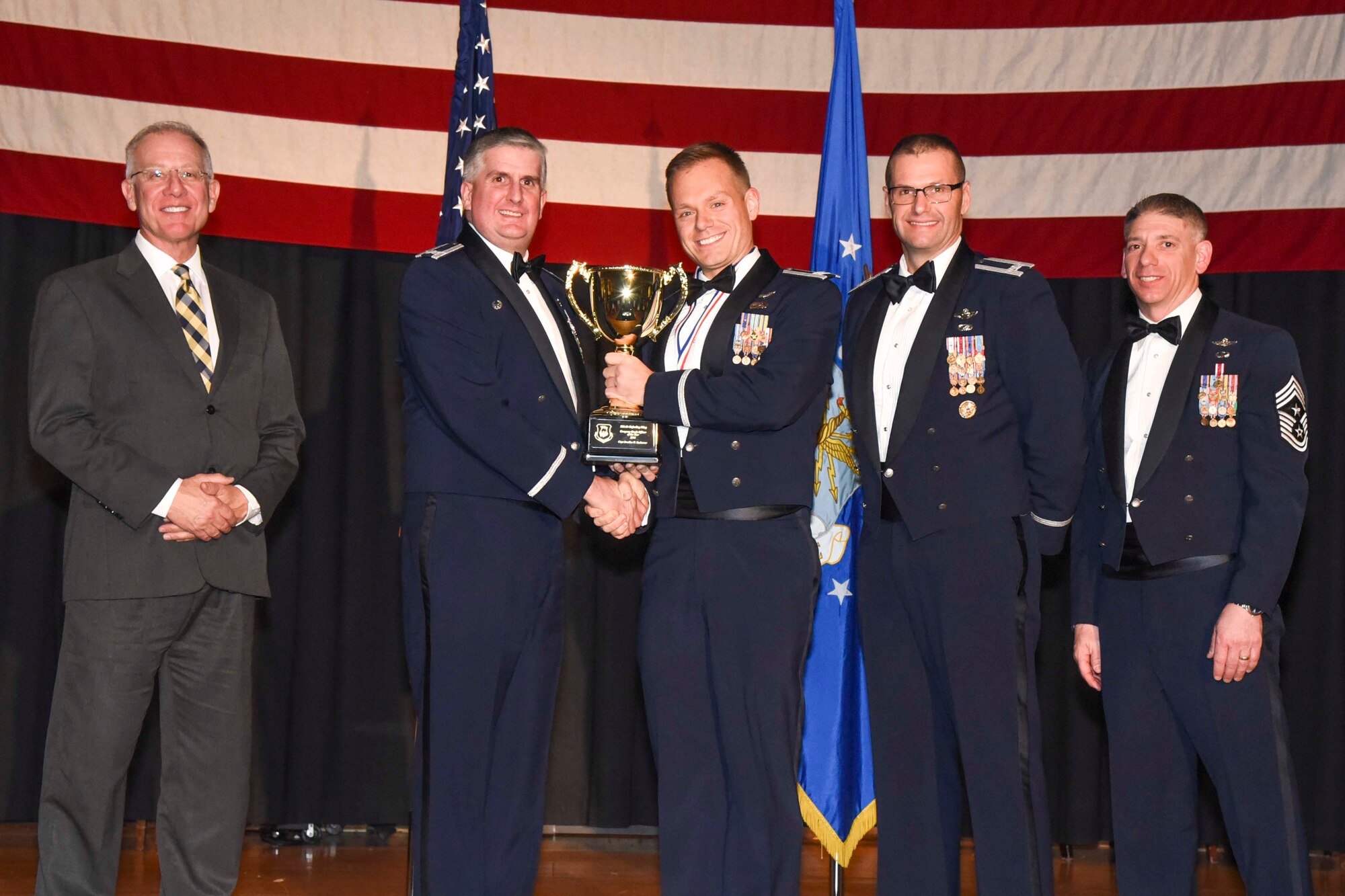 Capt. Bradlee N. Seehawer, center, accepts the 2016 Company Grade Officer of the Year award, Feb. 3, 2017, at McConnell Air Force Base, Kan. The annual awards ceremony recognized military and civilian members who excel in their areas of responsibilities, leadership qualities, community involvement, self-improvement and innovation from January to December 2016. (U.S. Air Force photo/Senior Airman Christopher Thornbury)