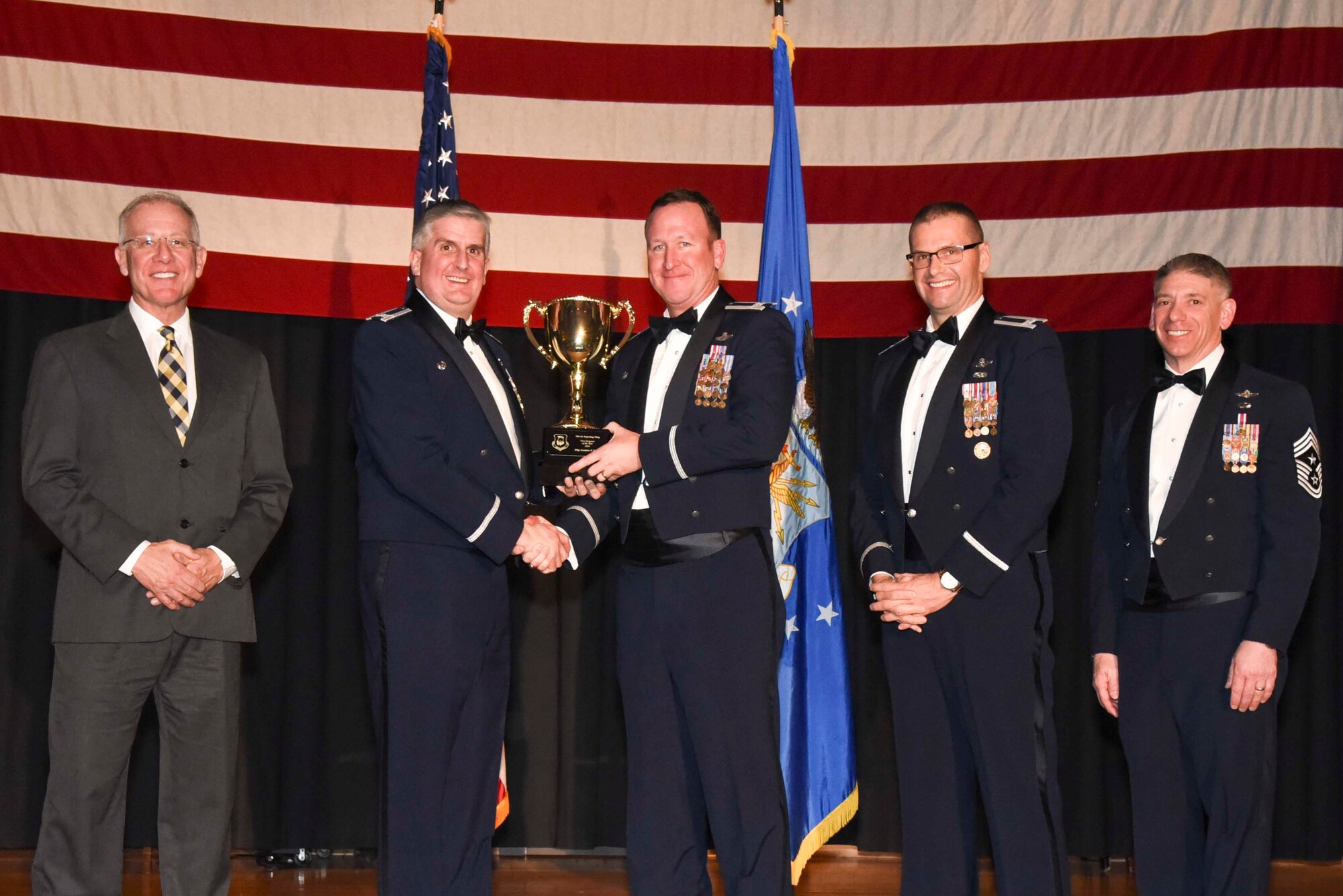 Col. David Lenderman, 22nd Operations Group commander, center, accepts the 2016 First Sergeant of the Year award on behalf of Master Sgt. Jonathan H. Bailey, 64th Air Refueling Squadron, Feb. 3, 2017, at McConnell Air Force Base, Kan. The annual awards ceremony recognized military and civilian members who excel in their areas of responsibilities, leadership qualities, community involvement, self-improvement and innovation from January to December 2016. (U.S. Air Force photo/Senior Airman Christopher Thornbury)
