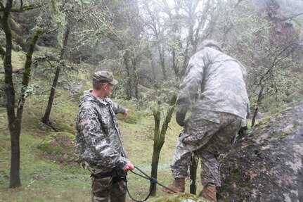 U.S. Army Reserve soldier Staff Sgt. Zackary Roony points Best Warrior Competitor Staff Sgt. Matthew Cassidy in the direction of the next obstacle during the obstacle course, Fort Hunter Liggett Calif. on February 7, 2017. The obstacle course was a timed event where soldiers competed individually for fastest time to complete the course. 