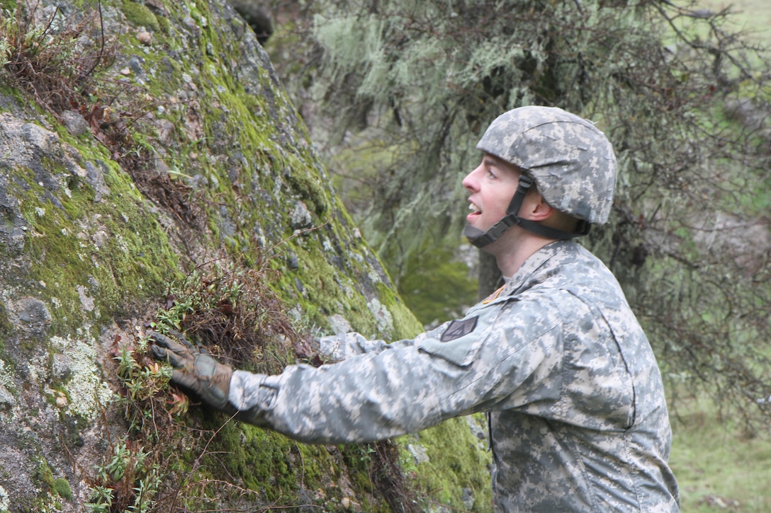 U.S. Army Reserve soldier Sgt. Robert Beedle assesses his next obstacle during the Best Warrior Competition, Fort Hunter Liggett, Calif. on February 7, 2017. This rock was a particularly hard challenge due to all of the rain. 