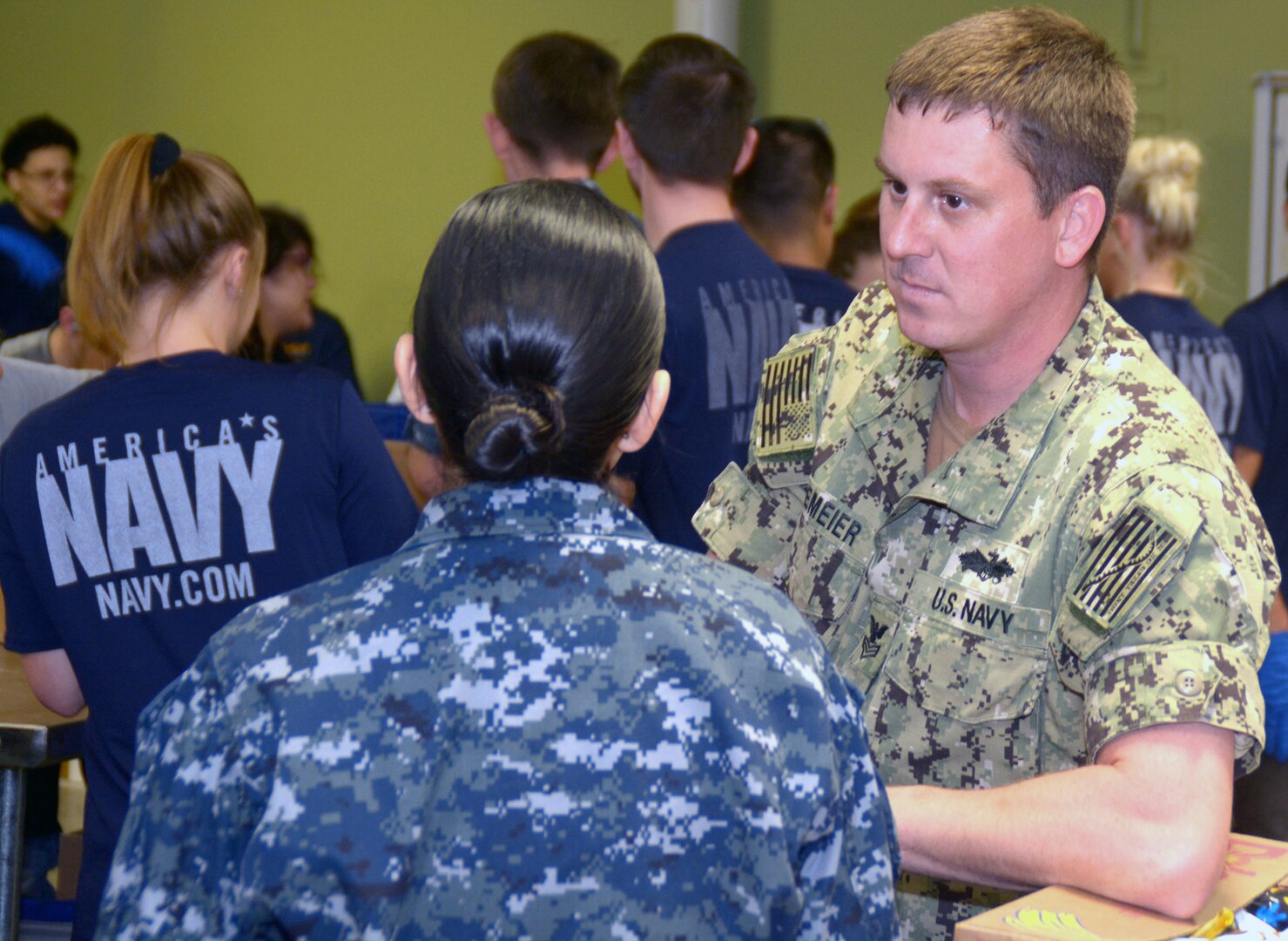 Petty Officer 1st Class Andrew Hagemeier, a recruiter assigned to  Navy Recruiting Station Northeast San Antonio, speaks with his leading chief petty officer, Chief Navy Counselor Isabel Laurel during a bi-weekly Delayed Entry Program  meeting held at the San Antonio Food Bank Feb. 1.  After the DEP meeting, recruiters along with more than 50 future Sailors volunteered at the food bank by sorting and packaging food items for donation. “It was a great way to build camaraderie while doing something wonderful for our city,” said Hagemeier, a 2005 graduate of Fargo North High School.  “This also shows the community how much the Navy values making our city better.”