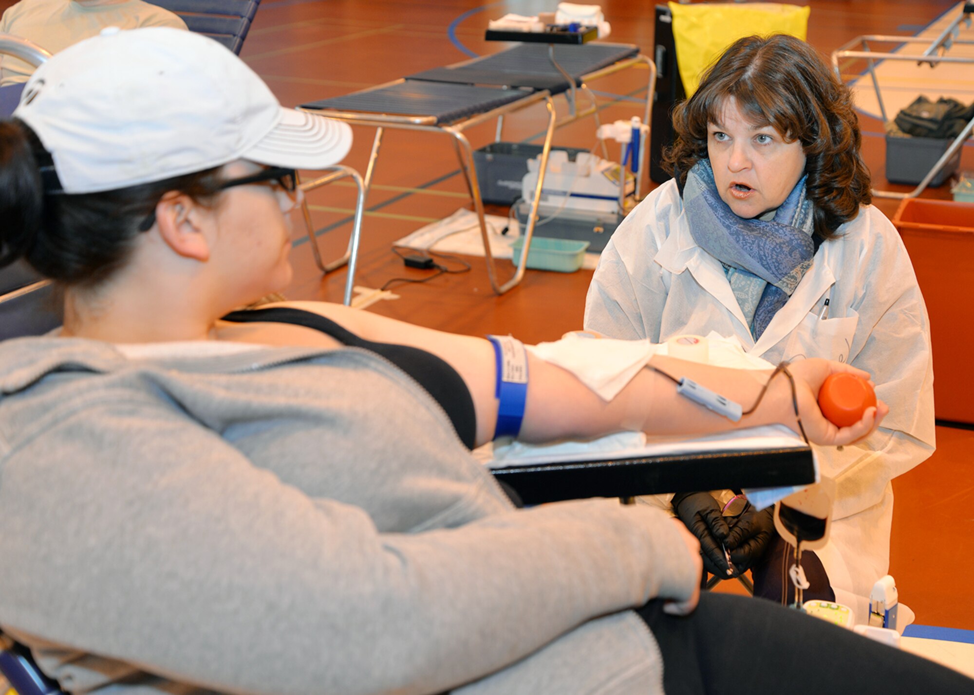 Alicia Murgolo, left, 48th Civil Engineer Squadron spouse, discusses the donation process with Pamela Hudson, phlebotomist technician from the Armed Services Blood Program-Europe, Landstuhl Regional Medical Center, Germany, as she gives blood Feb. 7, 2017, on RAF Mildenhall, England. More than 70 units of blood were donated by Team Mildenhall members, which will be used to support missions in European Command, Central Command and Africa Command, as well as in military treatment facilities.    (U.S. Air Force photo by Karen Abeyasekere)