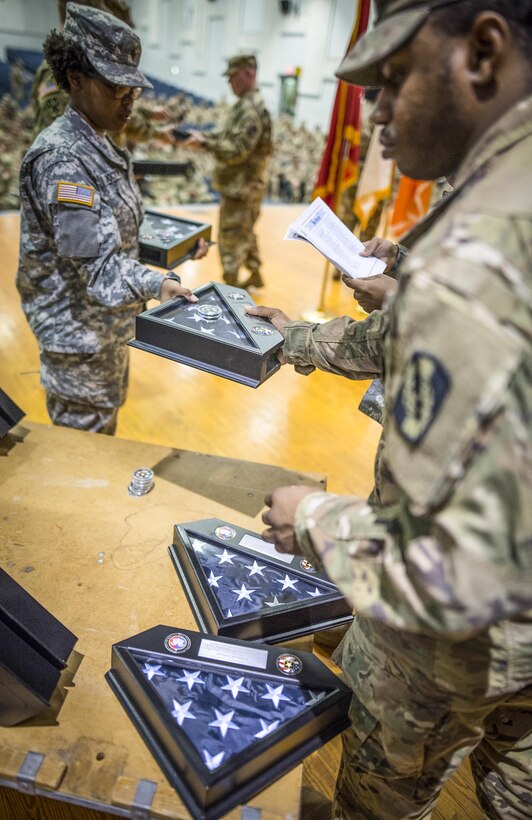 Soldiers with the 335th Signal Command (Theater) pass commorative flags to the stage of Fort Hood’s Howze Theater during a welcome home ceremony for the 392nd Expeditionary Signal Battalion, Feb. 6, 2017. 