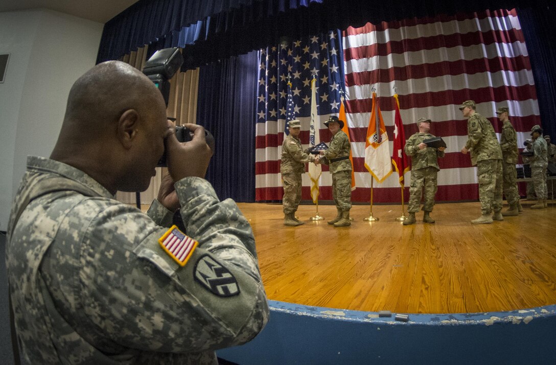 U.S. Army Reserve Sgt. Anthony Hooker, an Army photojournalist from Augusta, Ga., with the 359th Theater Tactical Signal Brigade, takes photo of Maj. Gen. Peter A. Bosse, commander of the 335th Signal Command (Theater), as he congratulates members of the 392nd Expeditionary Signal Battalion during a welcome home ceremony at Fort Hood, Texas, Feb. 6, 2017. The 392nd ESB had just returned from a nine-month deployment to the Middle East. 