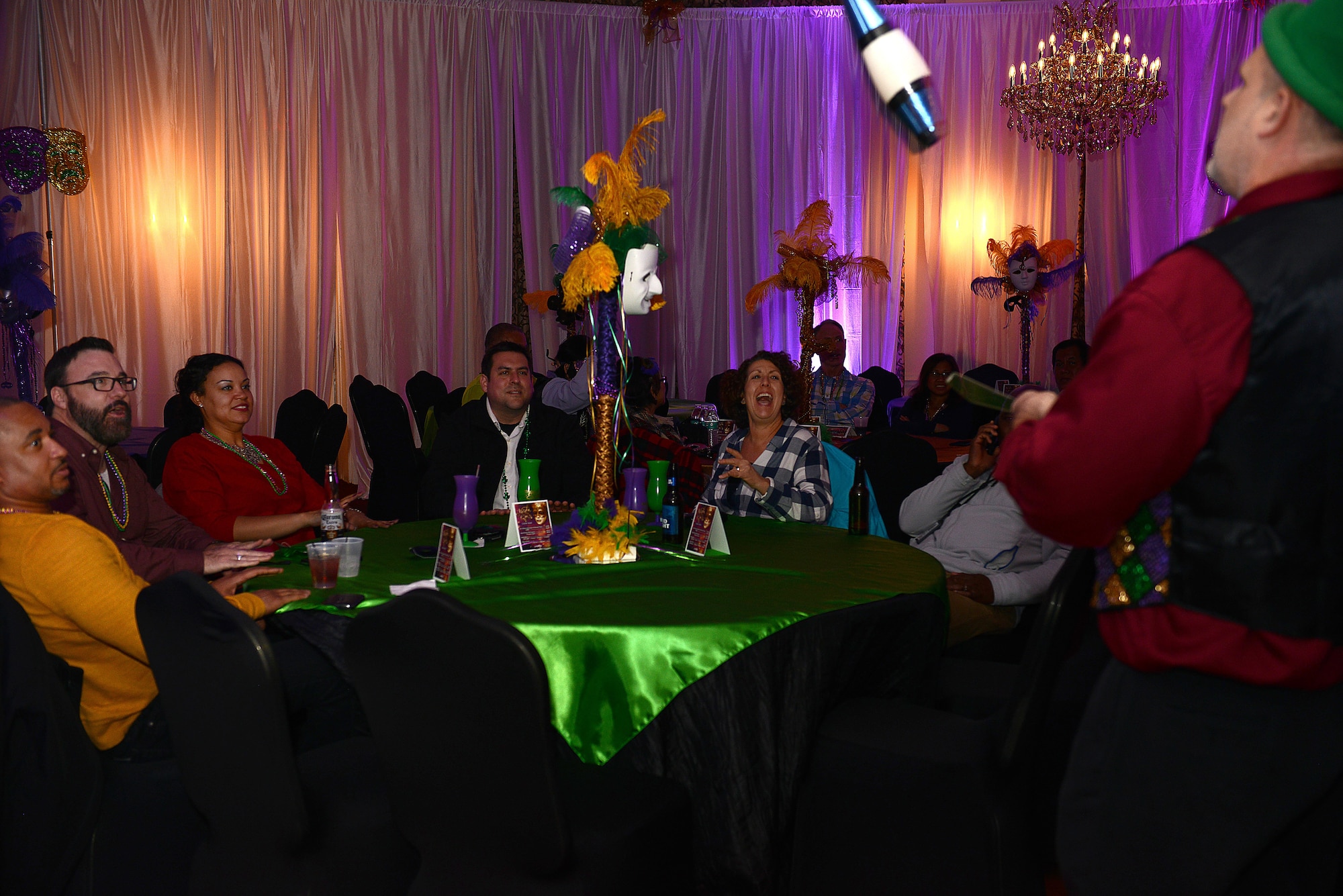 Guests watch a performer juggle bowling pins during the Mardi Gras event hosted at the Fort Eustis Club at Joint Base Langley-Eustis, Va., Feb, 3, 2017. Fortune tellers, makeup artists, jugglers and magicians provided entertainment for guests during the event. (U.S. Air Force photo by Staff Sgt. Teresa J. Cleveland)