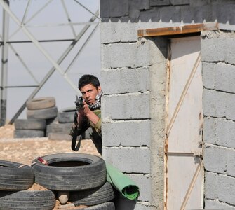 A Peshmerga soldier cautiously peers around a corner during urban operations training near Erbil, Iraq. Dutch and Norwegian soldiers, part of the Kurdistan Training Coordination Center, oversaw the day's training which included individual movement techniques, counter IED and entry control point procedures. The KTCC is a multi-national coalition dedicated to the training, advising and assistance of Kurdish forces to defeat ISIL in Iraq.