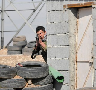 A Peshmerga soldier cautiously peers around a corner during urban operations training near Erbil, Iraq. Dutch and Norwegian soldiers, part of the Kurdistan Training Coordination Center, oversaw the day's training which included individual movement techniques, counter IED and entry control point procedures. The KTCC is a multi-national coalition dedicated to the training, advising and assistance of Kurdish forces to defeat ISIL in Iraq.