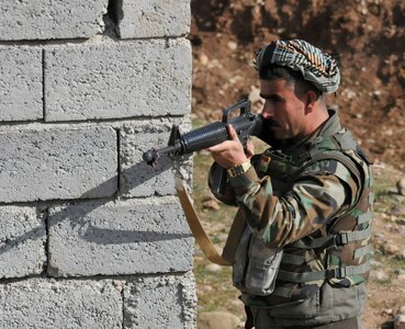 A Peshmerga soldier stands guard during urban operations training near Erbil, Iraq. Dutch and Norwegian soldiers, part of the Kurdistan Training Coordination Center, oversaw the day's training which included individual movement techniques, counter IED and entry control point procedures. The KTCC is a multi-national coalition dedicated to the training, advising and assistance of Kurdish forces to defeat ISIL in Iraq.