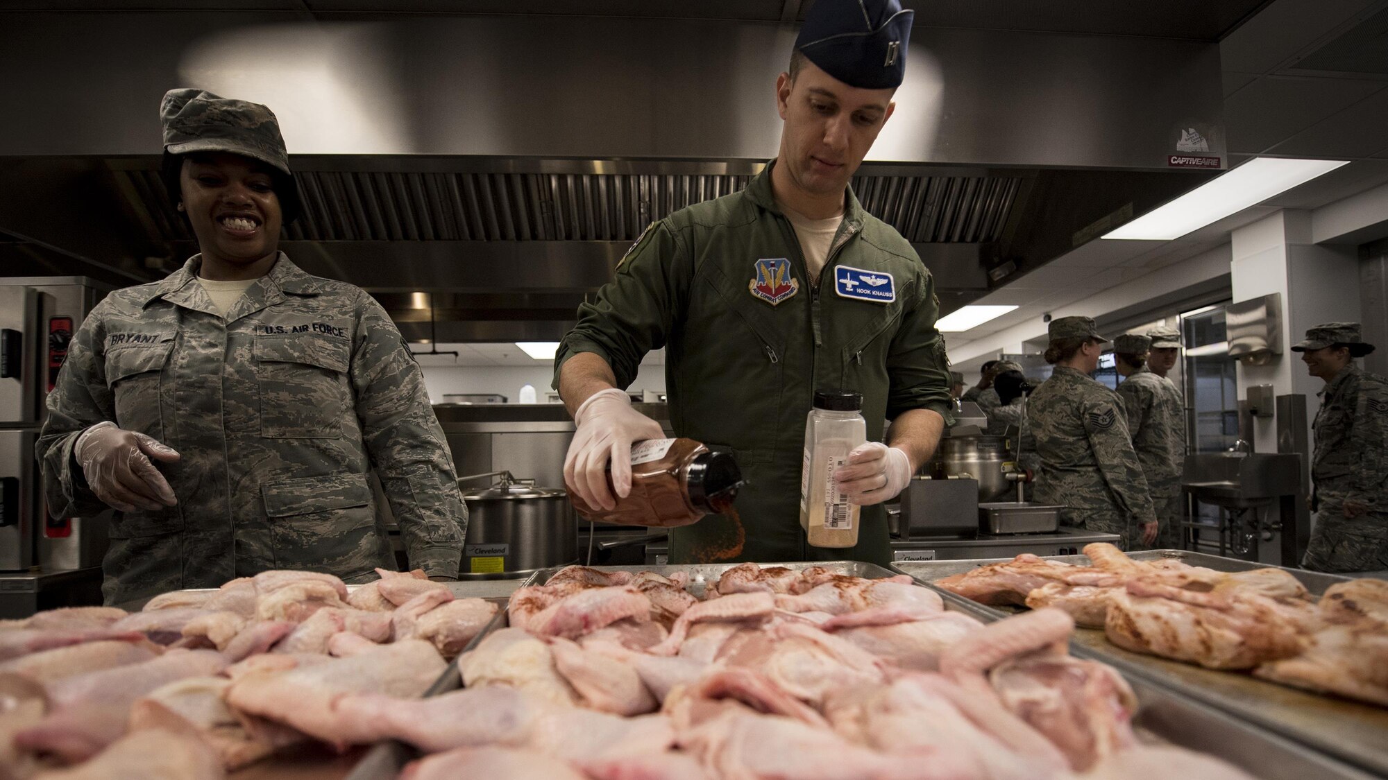 Capt. James Knauss, 74th Fighter Squadron A-10C Thunderbolt II pilot, seasons chicken portions while Staff Sgt. Arlene Bryant, 23d Force Support Squadron Georgia Pines Dining Facility shift supervisor, watches during an Emerge Moody course, Feb. 2, 2017, at Moody Air Force Base, Ga. Approximately 20 members are currently enrolled in the nine-month course and met for the fifth time as they continued to learn about different career fields across the base that contribute to the overall mission. (U.S. Air Force photo by Airman 1st Class Daniel Snider)