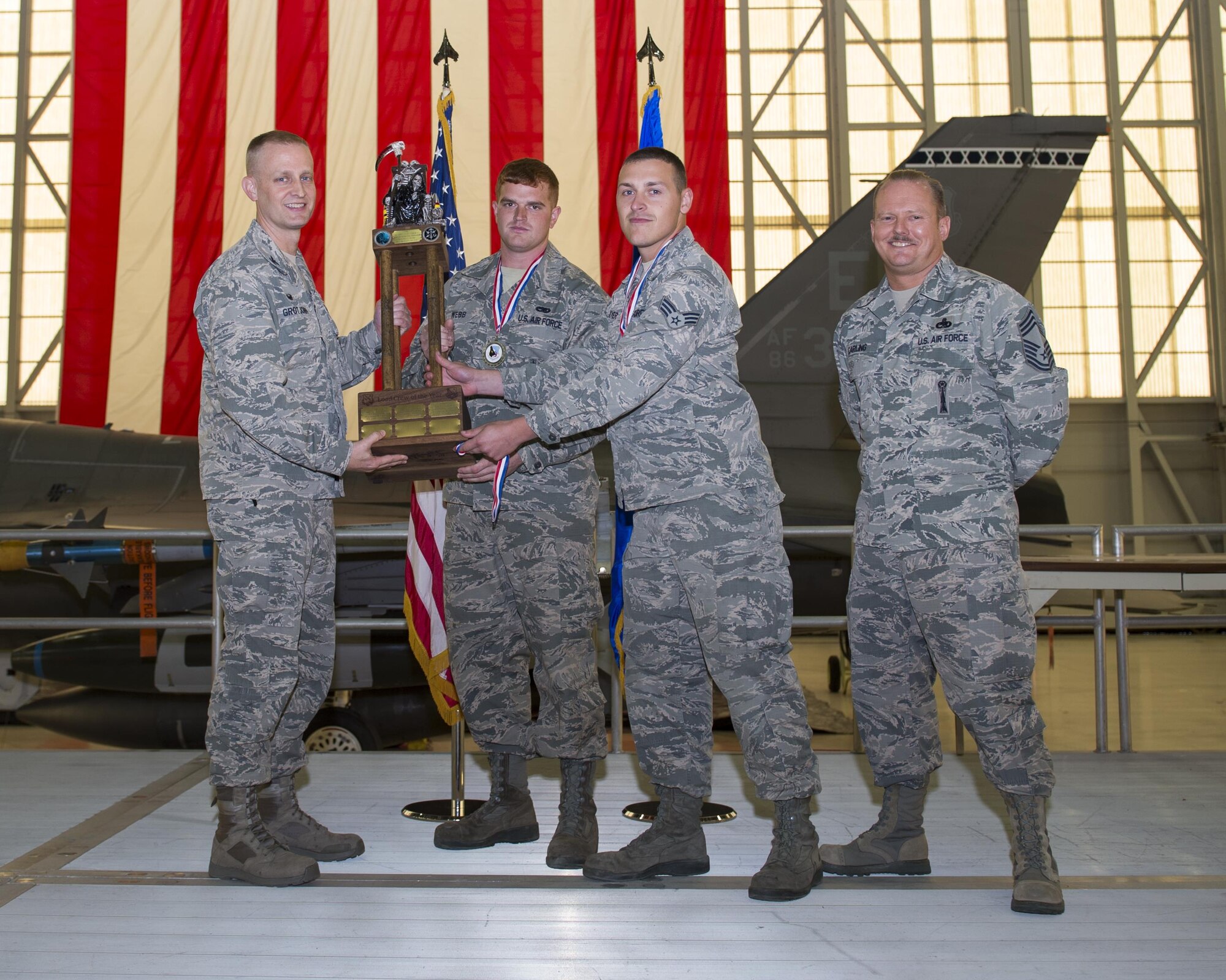 From left: Col. Stephen Grotjohn, 412th Maintenance Group commander, presents the 2016 Weapons Load Crew of the Year Award to Senior Airman Billy Webb and Senior Airman Michael Meyer along with wing weapons manager, Chief Master Sgt. Andrew Carling Feb. 6 in Hangar 1600. (U.S. Air Force photo by Joseph Gocong)