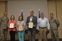 Col. Robert Lyman, left, 628th Air Base Wing commander, and Chief Master Sgt. Chad Ballance, right, 628th Medical Group superintendent, present  base civilian employees (left to right), Sandy Barker, Cesta Ford, Raymond Purdy and Walter Runck, with the Volunteer Excellence Award, during a commander’s call at the Charleston Club Feb 3, 2017.  The award recognizes individuals for their volunteer work in the community. 