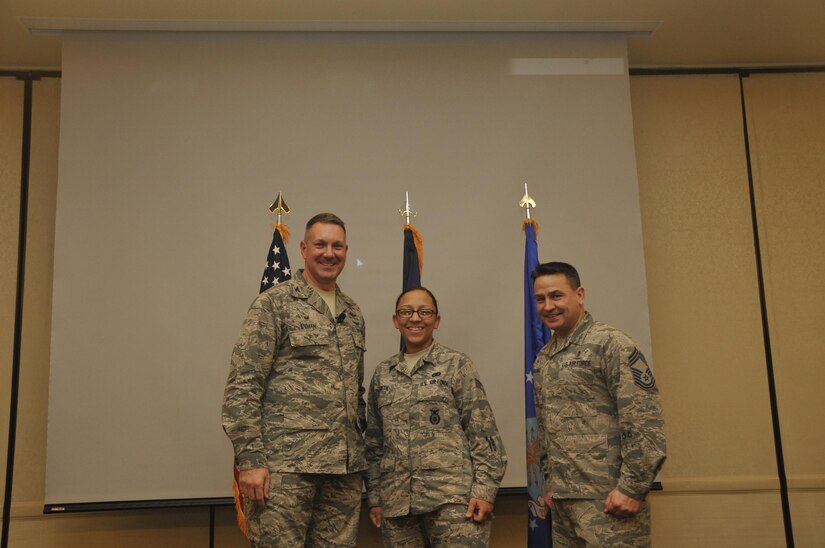 Senior Airman Mariah Smith, center, 628th Security Forces Squadron patrolman, is recognized by Col. Robert Lyman, left, 628th Air Base Wing commander, and Chief Master Sgt. Chad Ballance, right, 628th Medical Group superintendent, during a commander’s call at the Charleston Club Feb 3, 2017. Smith was coined for training 47 Airman and attending a principle of instruction course. 