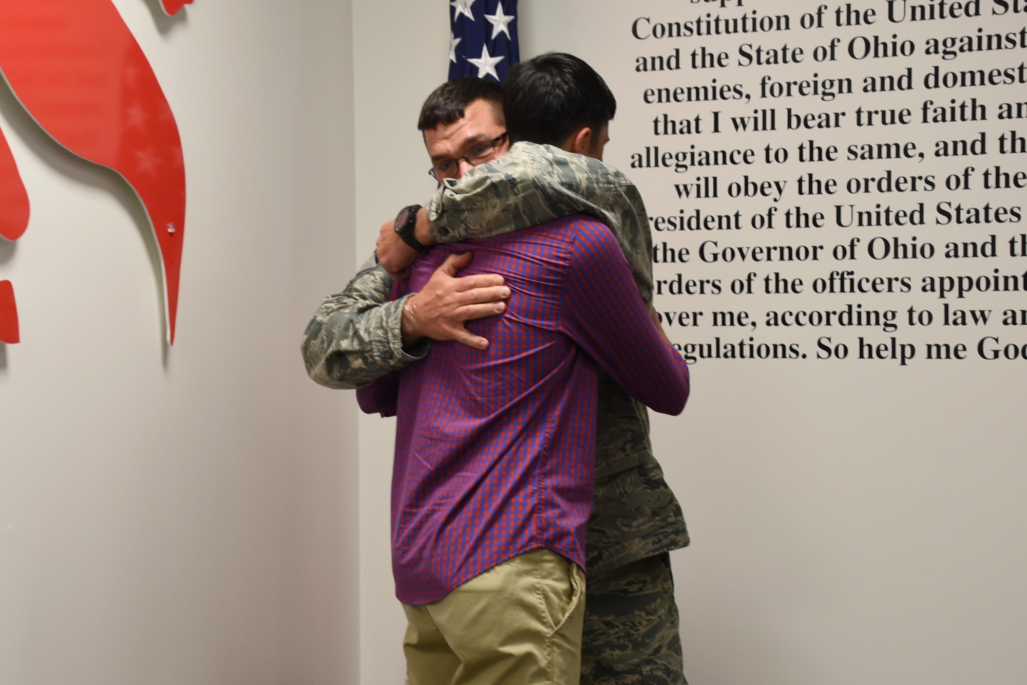 Senior Master Sgt. Roger Burton, the fire chief at the 179th AW, embraces his son Cooper Burton on Dec. 2, 2016, at the 179th Airlift Wing, Mansfield, Ohio. They both recited the oath of enlistment, Cooper for the first time and his father for the last time. Cooper is starting his first term as a crew chief for the 179th AW and Chief Burton is starting his final term of his career. (U.S. Air National Guard photo by Airman Megan Shepherd/Released)