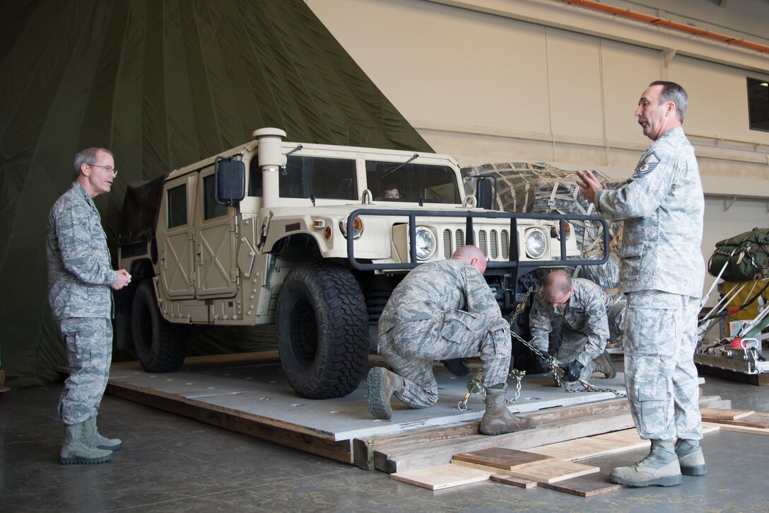 Staff Sgt. Bret Christofferson, 41st Aerial Port Squadron and Senior Airman Shane Tucher, 41st APS, demonstrate how to tie a Humvee down onto a palate while Master. Sgt. Steve Martin, 41st APS, explains the process to Maj. Gen. Robert LaBrutta, 2nd Air Force commander, during a 403rd Wing immersion tour Feb. 3 at Keesler Air Force Base, Mississippi. (U.S. Air Force photo/Staff Sgt. Heather Heiney)