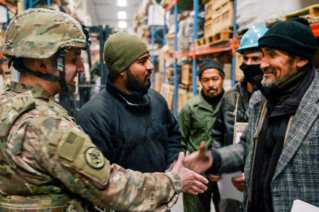 U.S. Air Force Capt. Jamey Shuls, Essential Function 5.1.3 combat advisor, shakes hands with an Afghanistan National Army warehouse supervisor during a discussion about logistics on storage and distribution for significant equipment and supplies in Kabul, Afghanistan, Jan. 26, 2017. Air Force image by Tech. Sgt. Jose A. Rodriguez Jr.