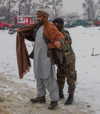 An Afghan soldier searches people receiving supplies in Afghanistan’s Parwan province during a humanitarian aid mission, Jan. 28, 2017. Army photo by Sgt. 1st Class Eliodoro Molina