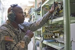 In this file photo, U.S. Army Reserve Spc. Anthony Lockey, a signal support systems specialist with the 338th Harbormaster Operations Detachment, Joint Base Langley-Eustis, Va., monitors and maintains equipment during training at Big Logistics-Over-The-Shore.  
