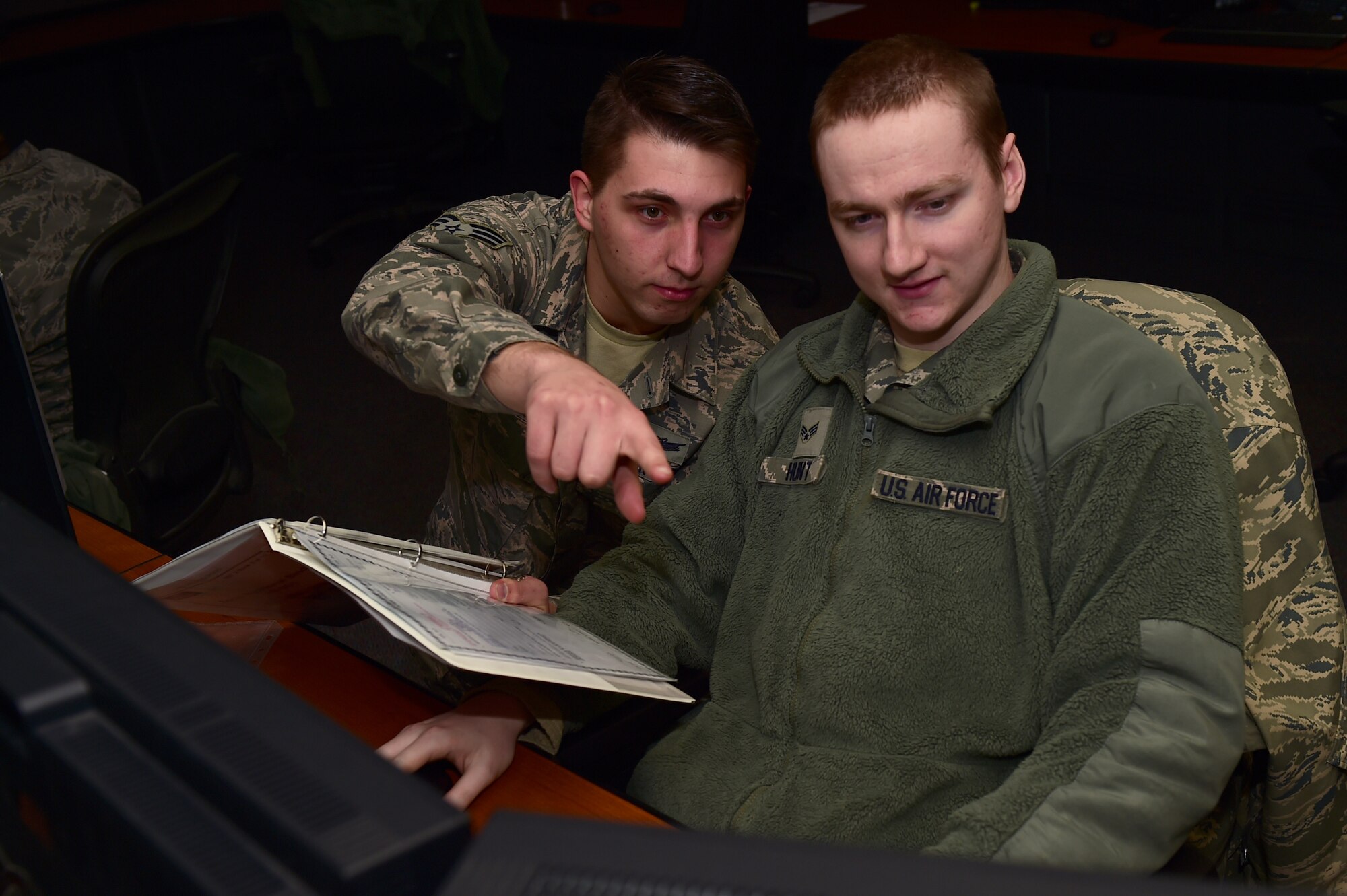Senior Airman Jacob Bercel, 8th Space Warning Squadron satellite systems operator, helps fellow classmate, Senior Airman Samuel Hunt, 2nd Space Warning Squadron satellite systems operator, Jan. 19, 2017, during a class on Buckley Air Force Base, Colo. The class was for space operators to learn more about commanding satellites and responding to anomalous conditions on the satellites. The Buckley AFB helping agencies allow operators to focus on the 460th Space Wing mission. (U.S. Air Force photo by Airman 1st Class Gabrielle Spradling/Released)