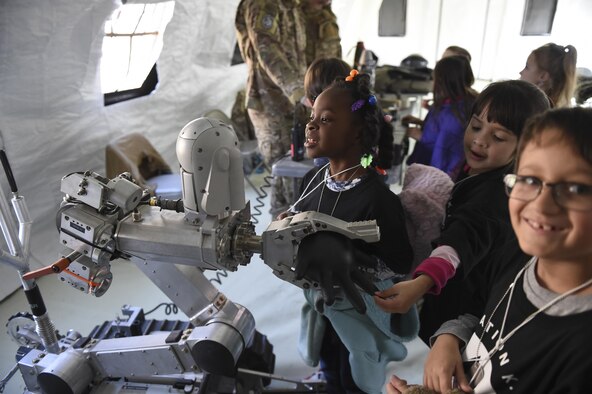 A group of children look at equipment from the 49th Civil Engineer Squadron Explosive Ordnance Disposal unit during Operation Kids Investigating Deployment at Holloman Air Force Base, N.M., Feb. 3, 2017. Operation KID is an annual event allowing children of military members to acquire a better understanding of what their parent goes through prior to a deployment. Military children were given a walk around the Basic Expeditionary Airfield Resources compound to see a mock deployment site, a mission brief, painted their faces, tried on Mission Oriented Protective Posture gear, and learn about different equipment including the opportunity to see a robot demonstration from Holloman’s EODl unit. (U.S. Air Force photo by Staff Sgt. Stacy Jonsgaard)