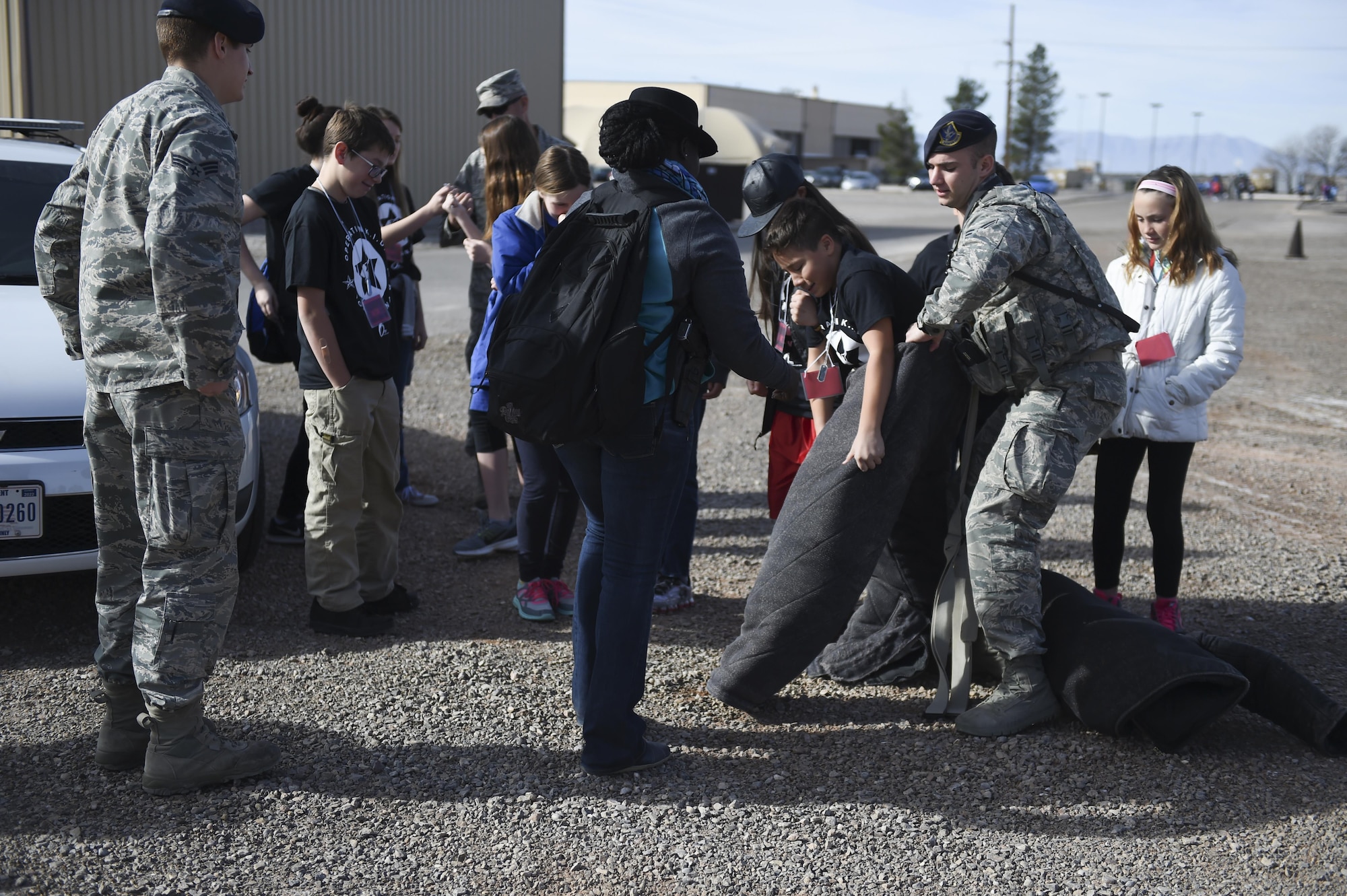 A group of children take turns wearing the bite suit with help from the 49th Security Forces Squadron Military Working Dog team with during Operation Kids Investigating Deployment at Holloman Air Force Base, N.M., Feb. 3, 2017. Operation KID is an annual event allowing children of military members to acquire a better understanding of what their parent goes through prior to a deployment. Military children were given a walk around the Basic Expeditionary Airfield Resources compound to see a mock deployment site, a mission brief, painted their faces, tried on Mission Oriented Protective Posture gear, and learn about different equipment including the opportunity to see a robot demonstration from Holloman’s EOD unit. (U.S. Air Force photo by Staff Sgt. Stacy Jonsgaard)