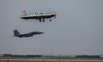 An F-15E Strike Eagle prepares to land while a T-6A Texan II takes off from Laughlin Air Force Base, Texas, Feb. 3, 2017. Onboard the Strike Eagle, Capt. Michael Broyles, 335th Fighter Squadron weapons system officer, returns to Laughlin, his childhood home. (U.S. Air Force photo/Airman 1st Class Benjamin N. Valmoja)