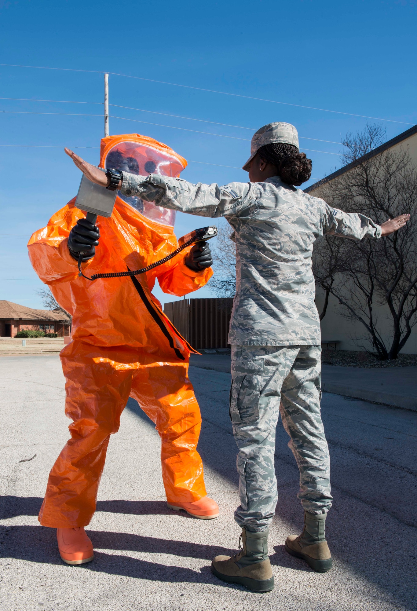 U.S. Air Force 1st Lt. Zachary Spranger, 7th Civil Engineer Squadron readiness and emergency management flight commander, (left) uses an ADM-300 tool to search for alpha radiation on Airman 1st Class Julia Scholar, 7th CES emergency management logistics, at Dyess Air Force Base, Texas, Feb. 8, 2017. The Dyess Air Force Base readiness and emergency management flight prepares, plans, trains, educates and equips installation personnel to respond to major accidents, natural disasters, weapons of mass destruction, and wartime chemical, biological, radiological and nuclear attacks. They provide technical expertise to commanders during response operations and perform detection, monitoring, warning and reporting in an effort to save lives, minimize the loss or degradation of resources and restore operational capability. (U.S. Air Force photo by Airman 1st Class Austin Mayfield)