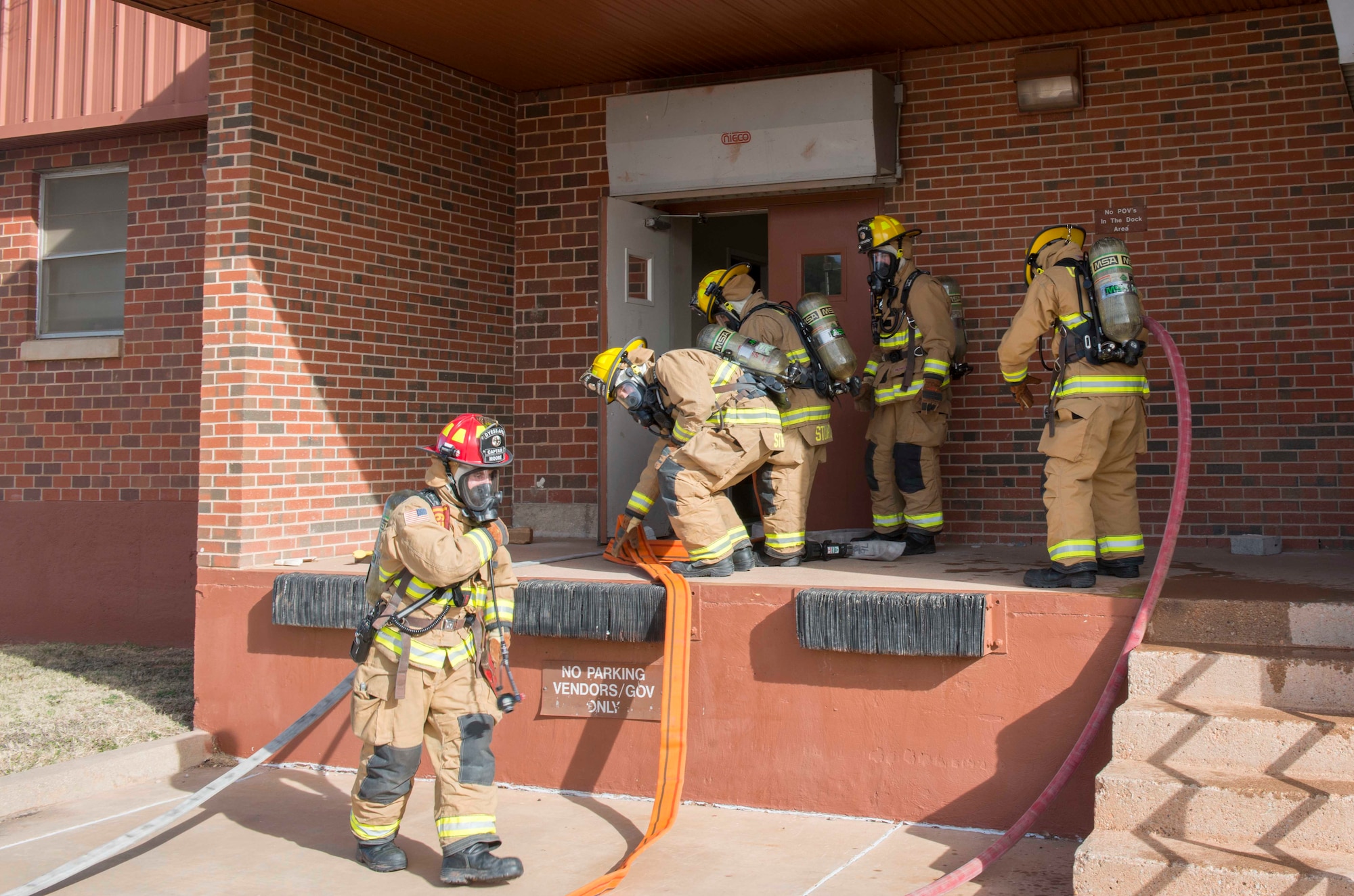 U.S. Air Force Airmen assigned to the 7th Civil Engineer Squadron Fire Department, prepare to go inside a simulated burning building at Dyess Air Force Base, Texas, Feb. 8, 2017. The 7th CES Fire Department conducted a library structural drill to prepare the Airmen for real-world scenarios. During this drill, they learn how to track down the source of the fire, how to best commit their resources to combating the fire and about the equipment used throughout these processes. (U.S. Air Force photo by Airman 1st Class Austin Mayfield)