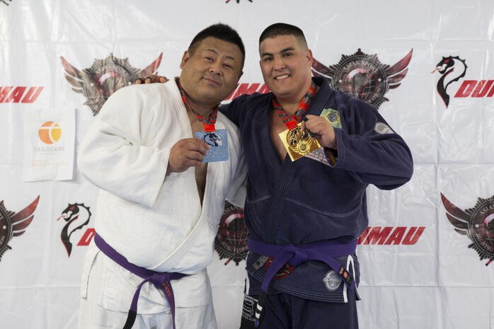 U.S. Marine Corps Master Sgt. Marcos Martinez, expeditionary fire rescue staff noncommissioned officer in charge with Marine Wing Support Squadron (MWSS) 171, right, poses for a photo with his opponent during the Duamau Tournament, a jiu jitsu competition at the TK Training Center in Hiroshima, Japan, Feb. 5, 2017. Jiu jitsu is a sport that teaches competitors to respect their opponents and build on the differences. Martinez trains among other Marines at the Iron Works North gym on Marine Corps Air Station Iwakuni. (U.S. Marine Corps photo by Lance Cpl. Joseph Abrego)